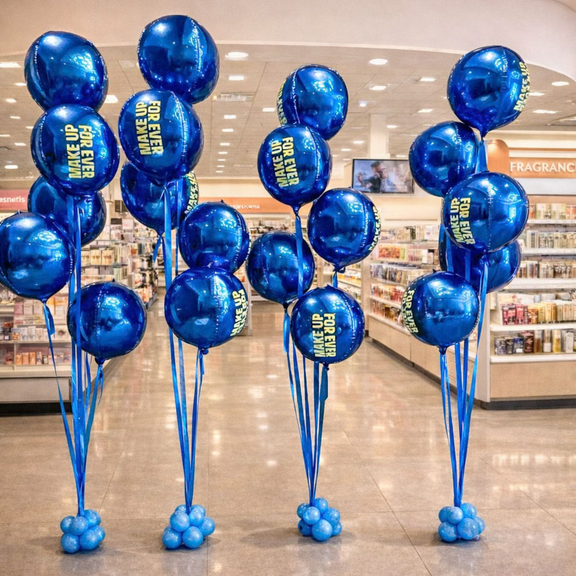 Blue balloons in a store, some with text, attached to bases and stands, in a store setting.