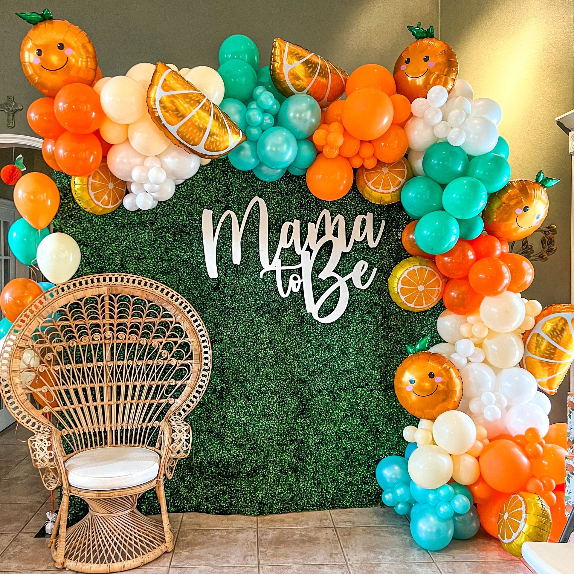 a wicker chair is sitting in front of a wall decorated with balloons .