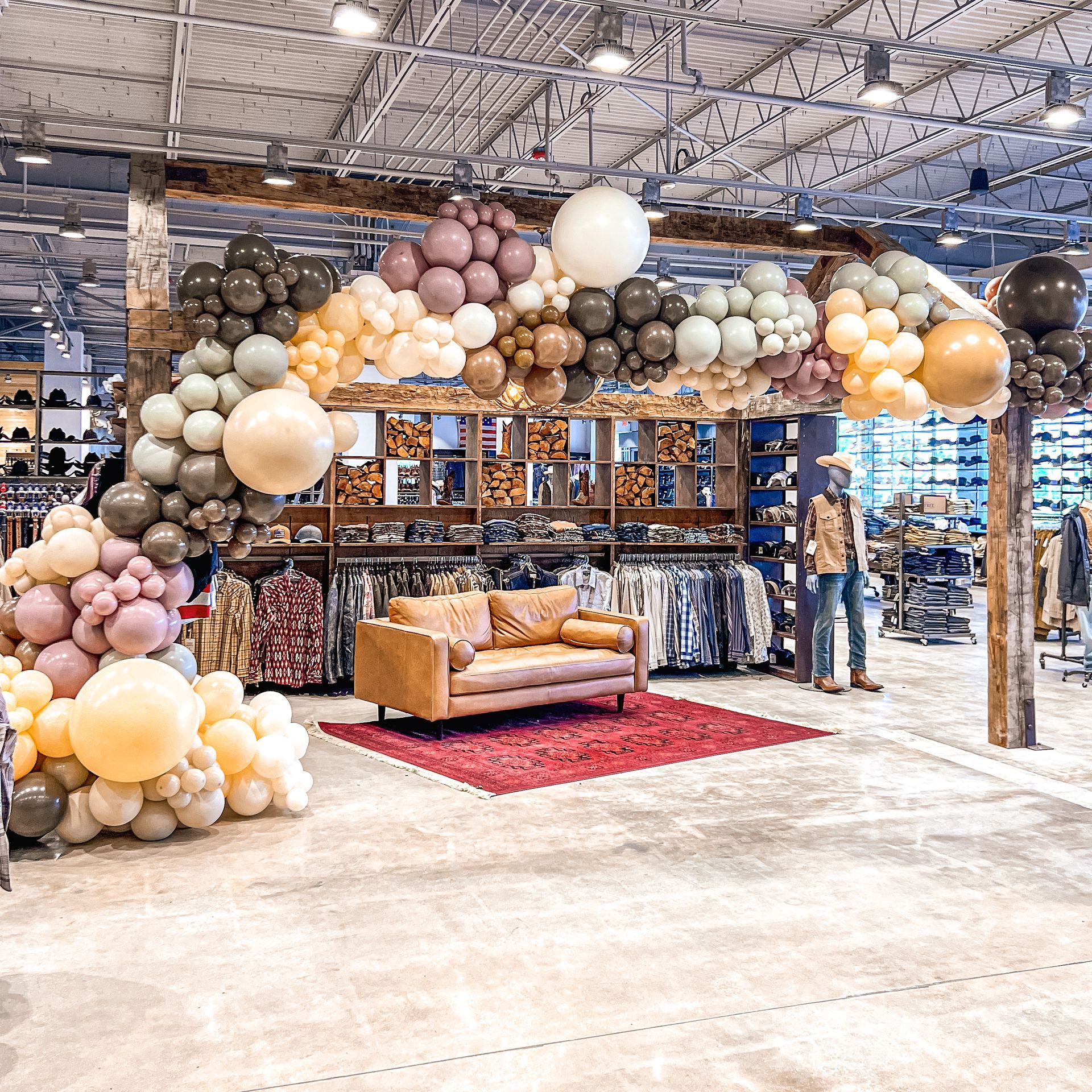 A store filled with balloons and a couch.