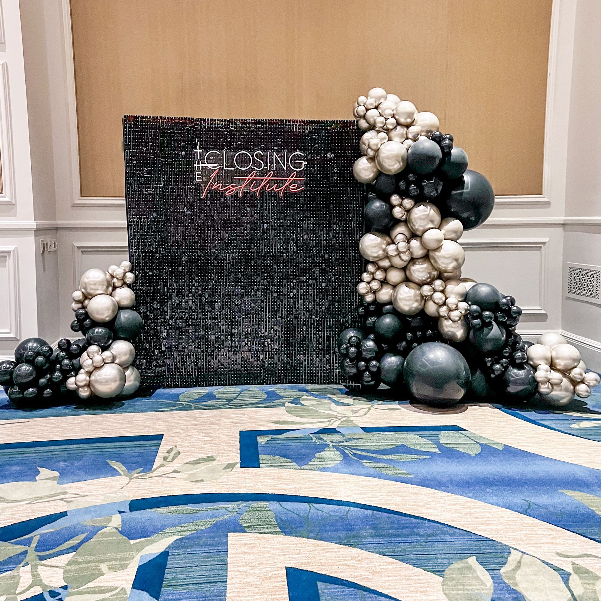 A room with a rug and balloons on the floor.