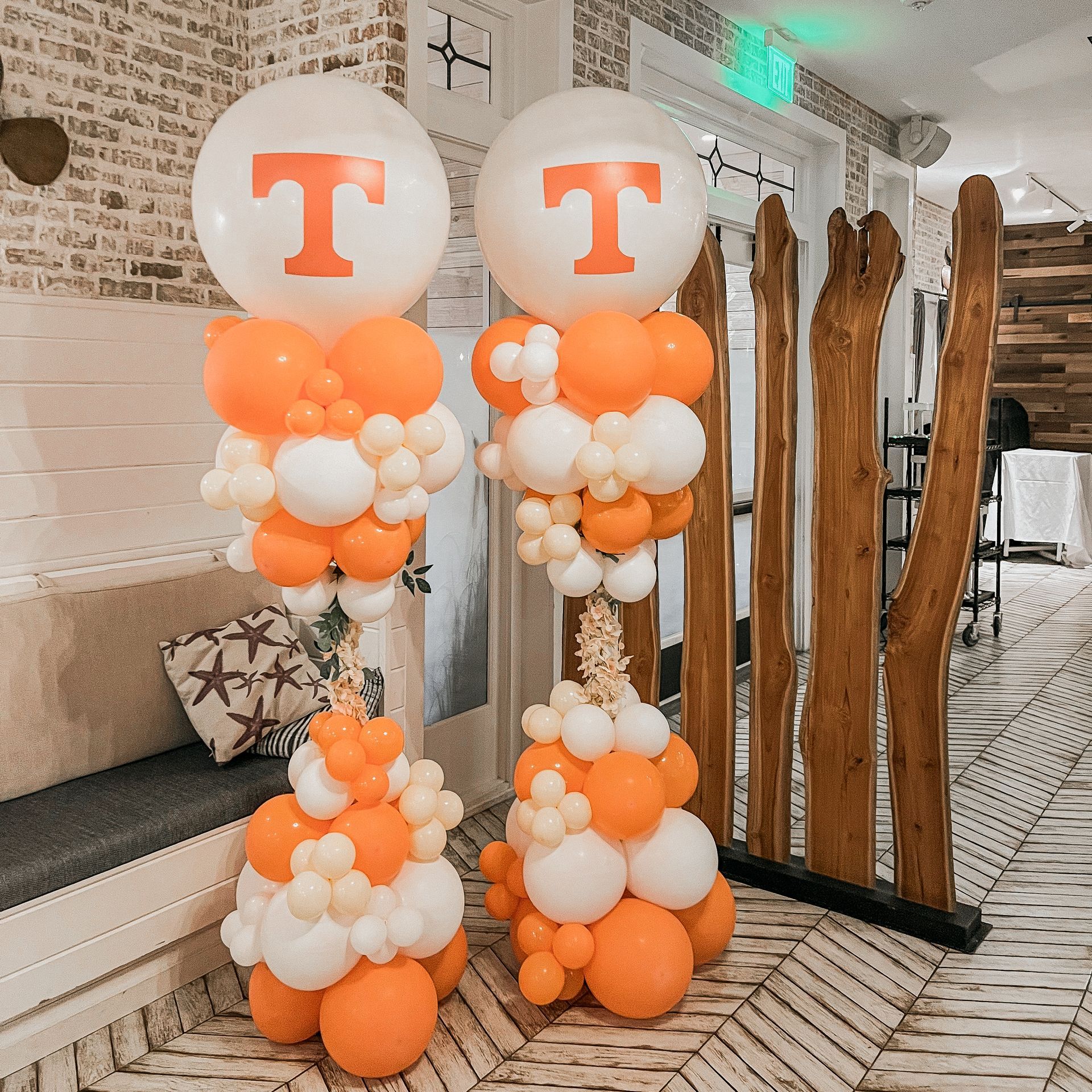 Two columns of orange and white balloons with the letter t on them