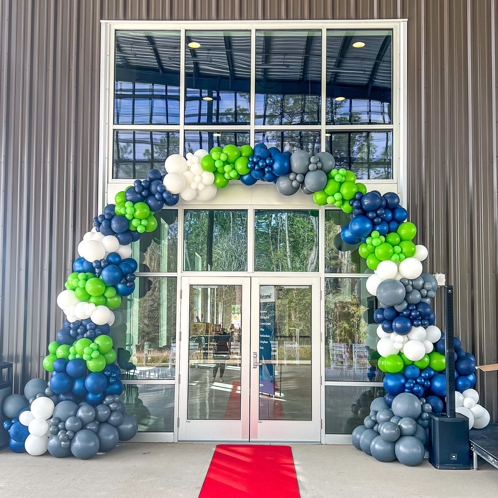 A large building with a balloon arch in front of it.
