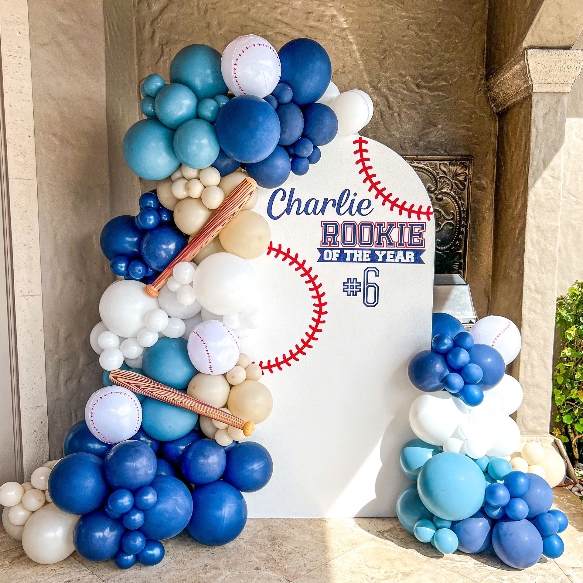 a bunch of blue and white balloons are stacked on top of each other in the shape of a baseball .