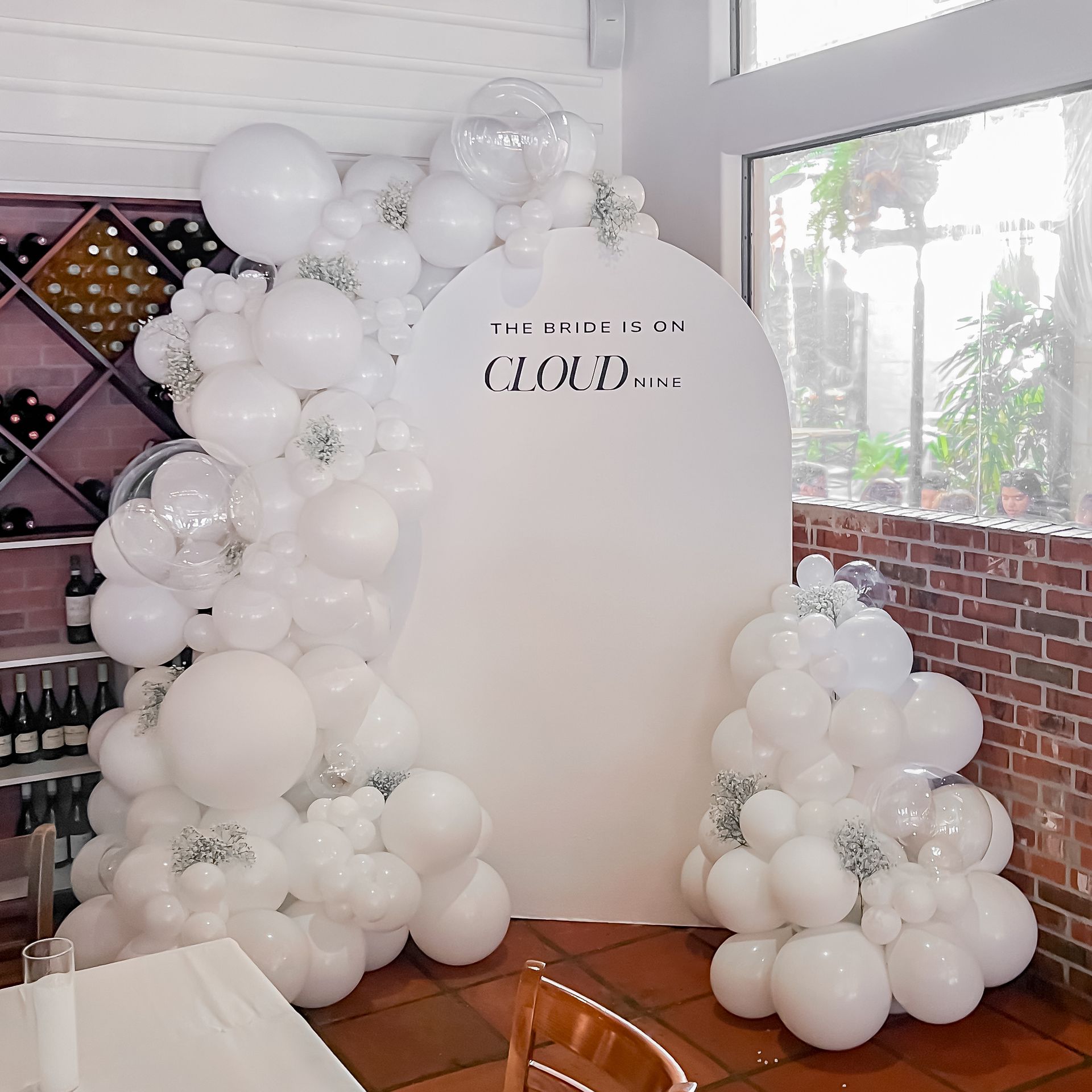 a room filled with white balloons and a sign that says cloud .