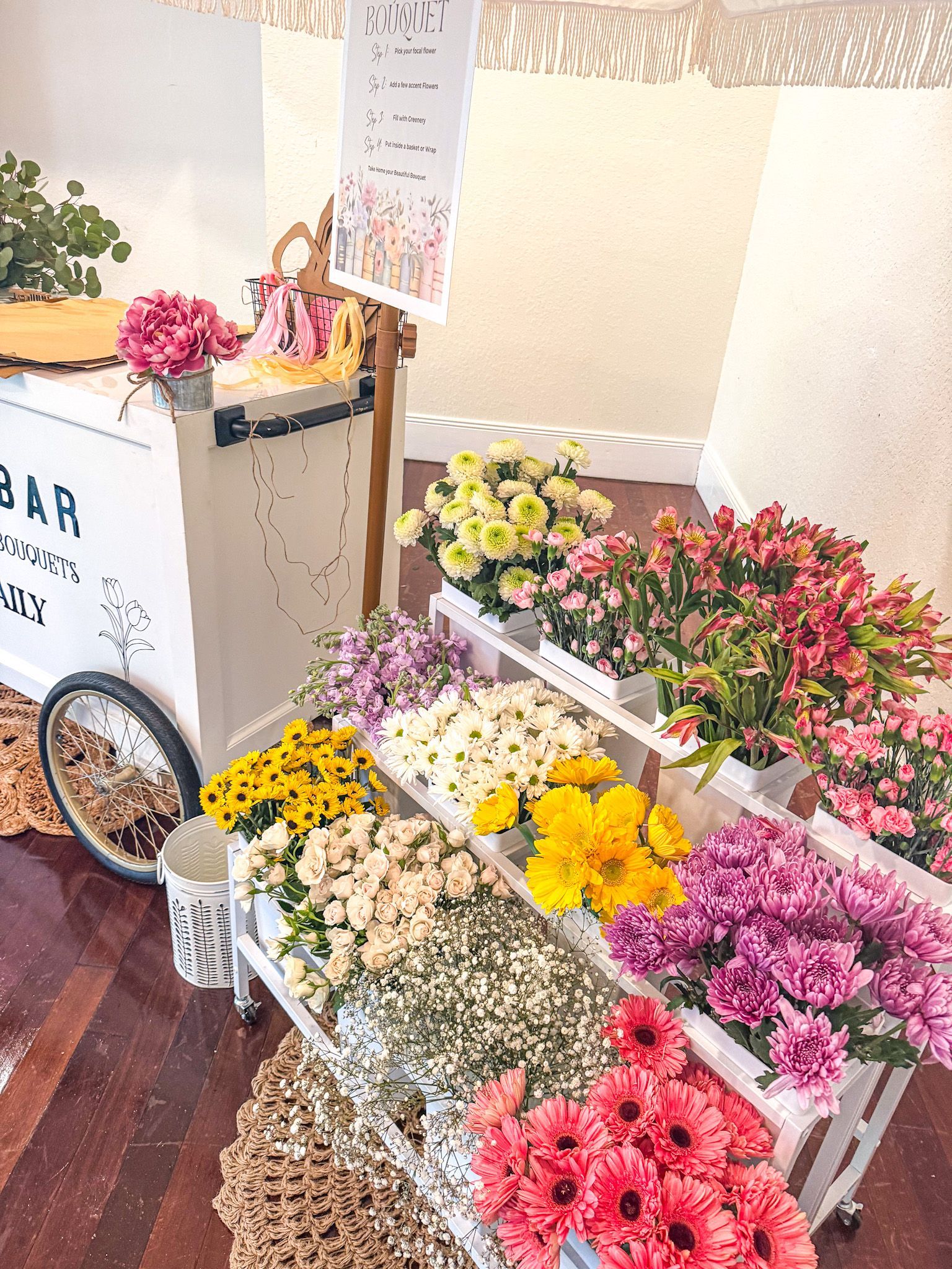 Flower cart with various colorful blooms on display for sale.