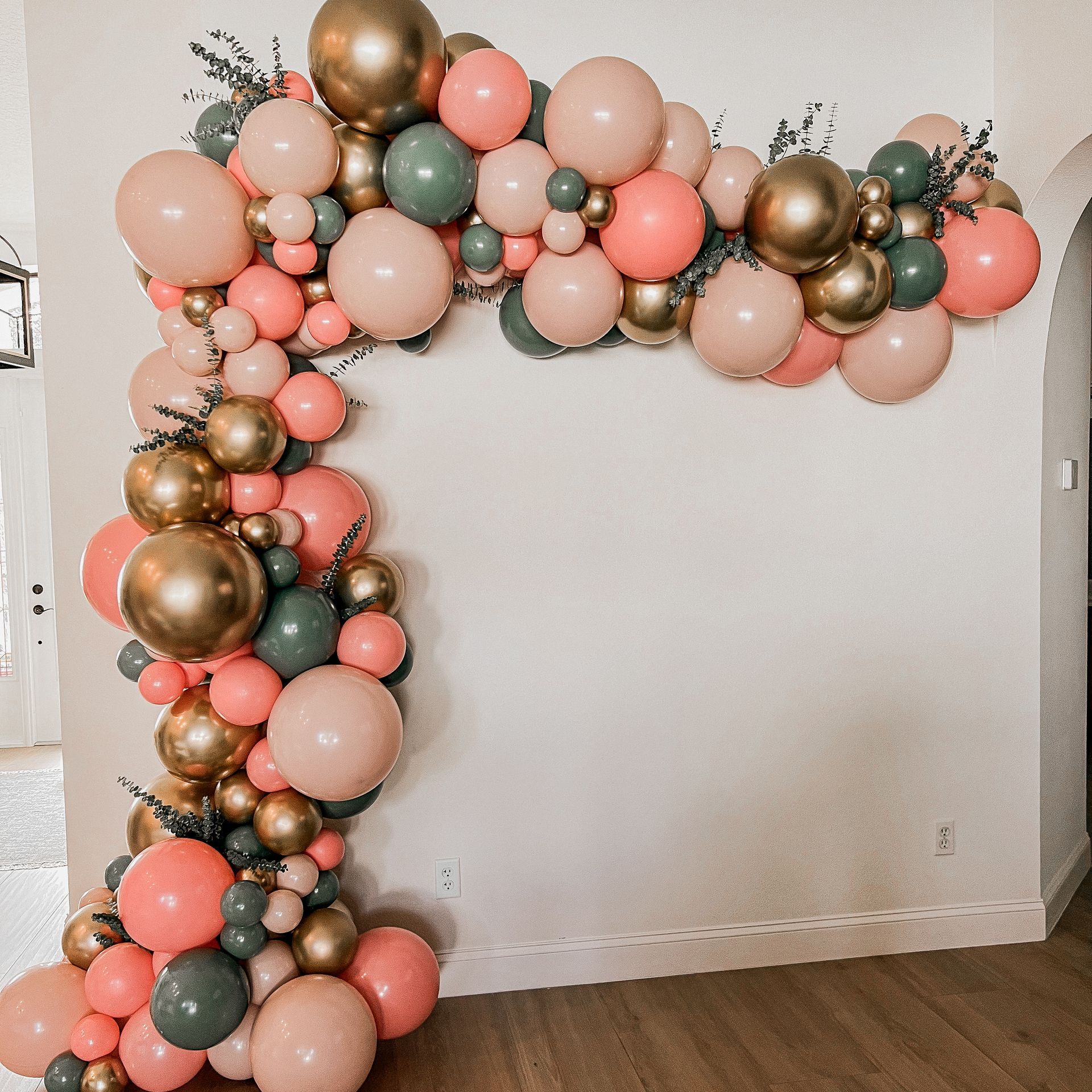 A bunch of balloons are hanging on a wall in a room.