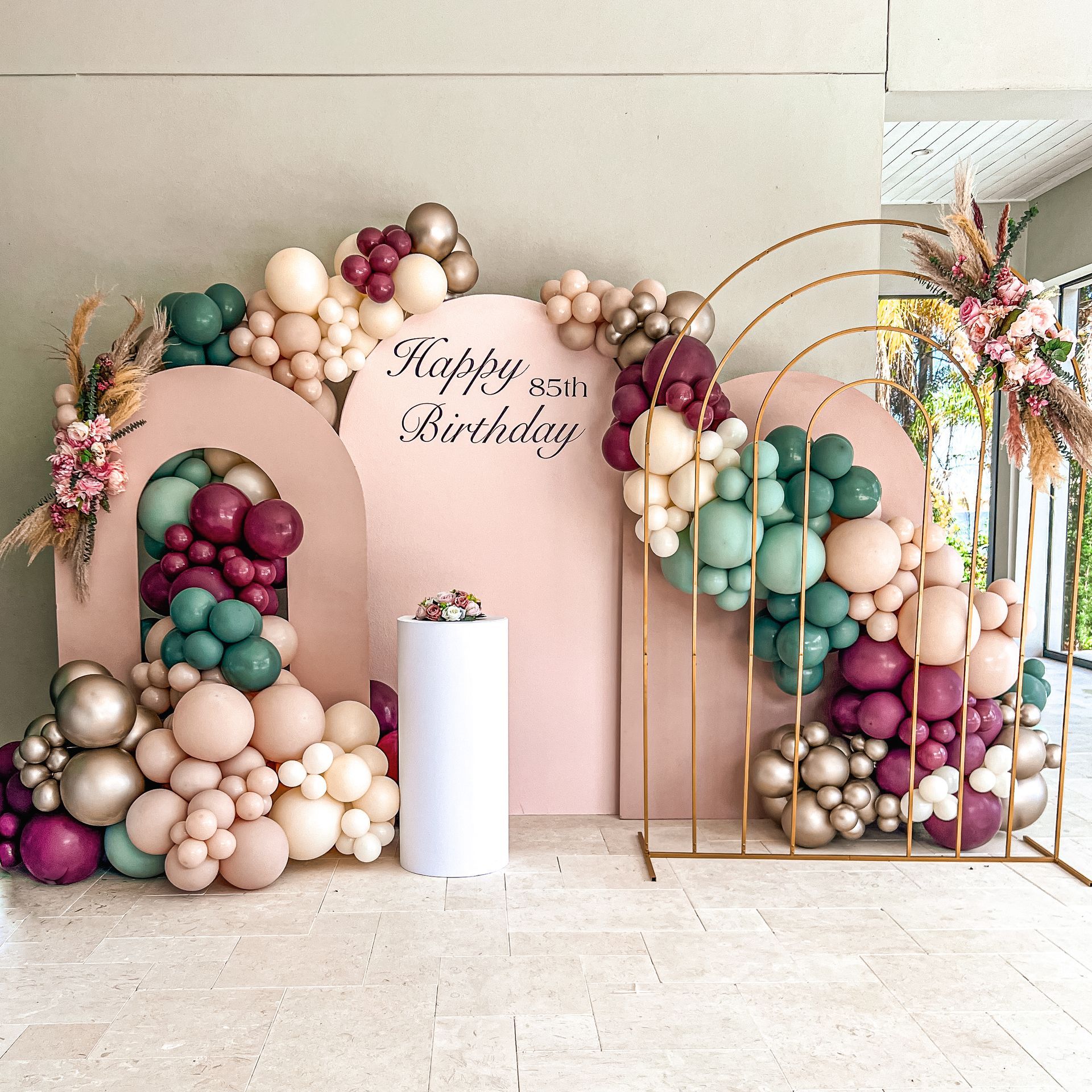 a room decorated with balloons and flowers for a birthday party .