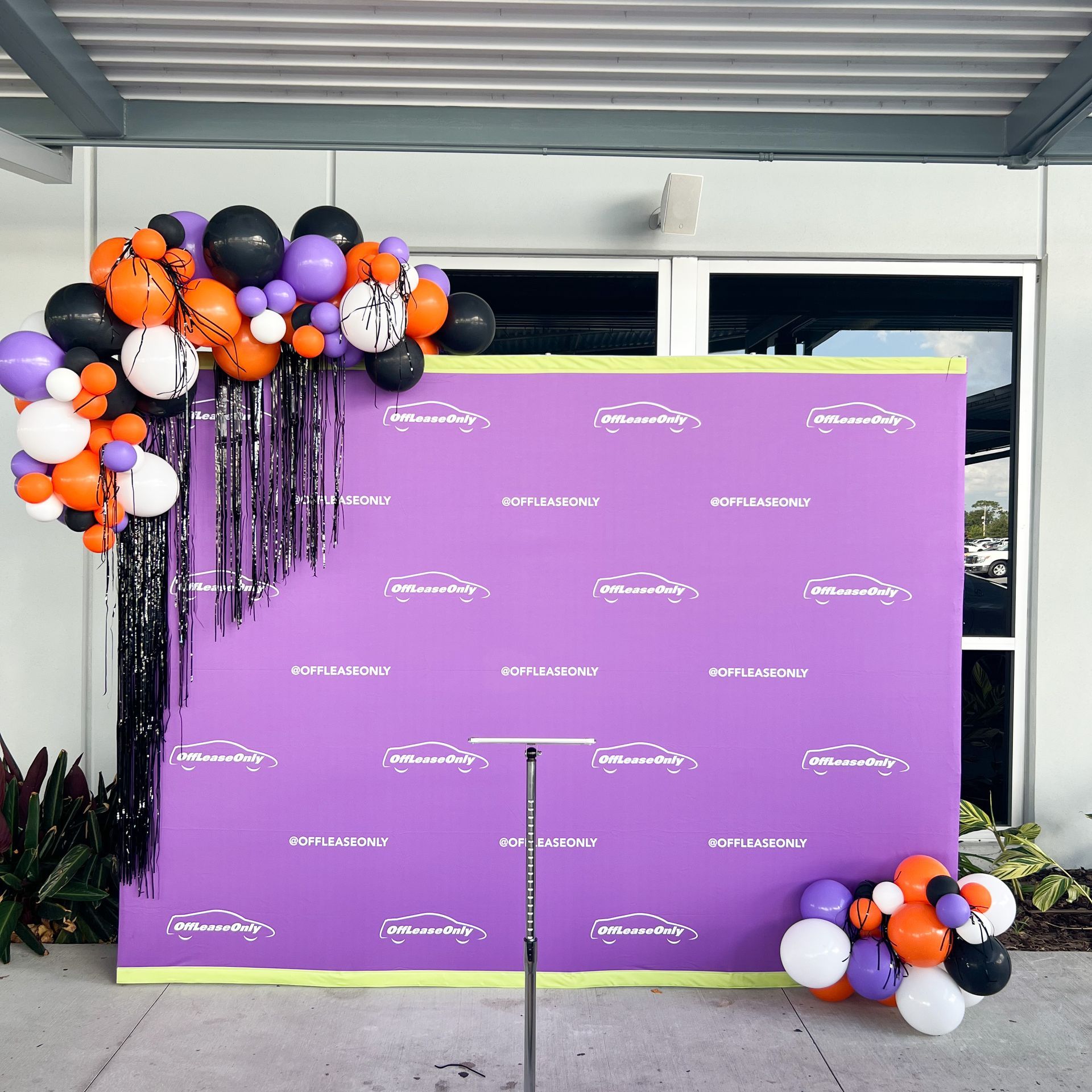 A purple backdrop with balloons and tinsel on it