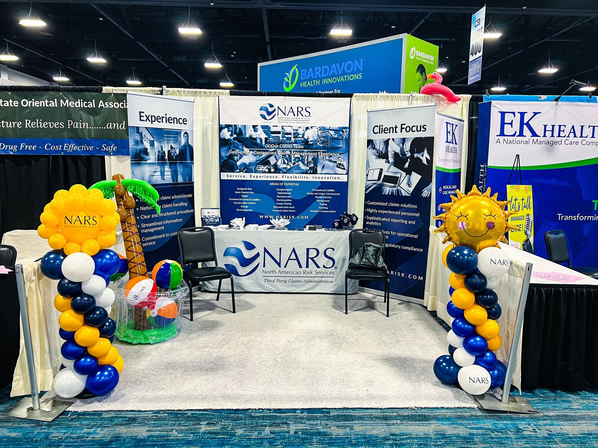 A nars booth is decorated with balloons and a sun.