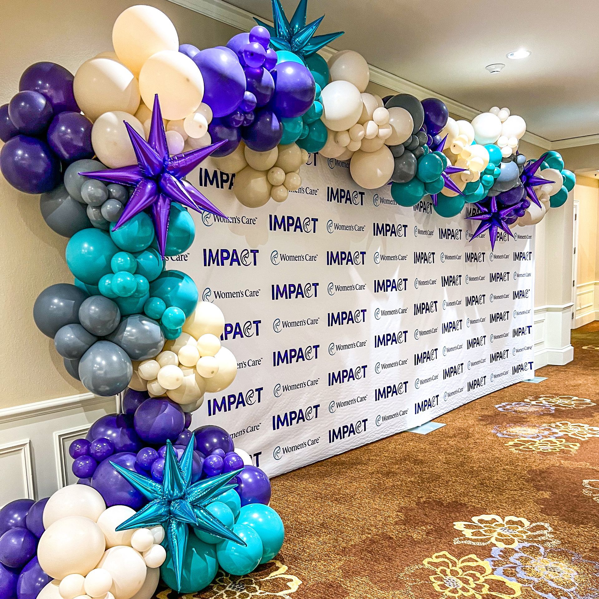 A wall covered in balloons with the word impact on it