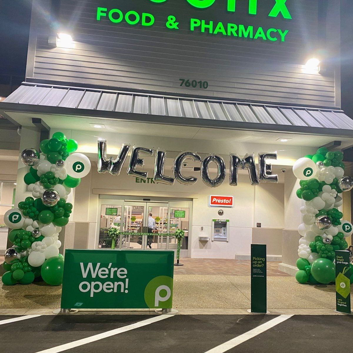 A store front with balloons and a sign that says welcome