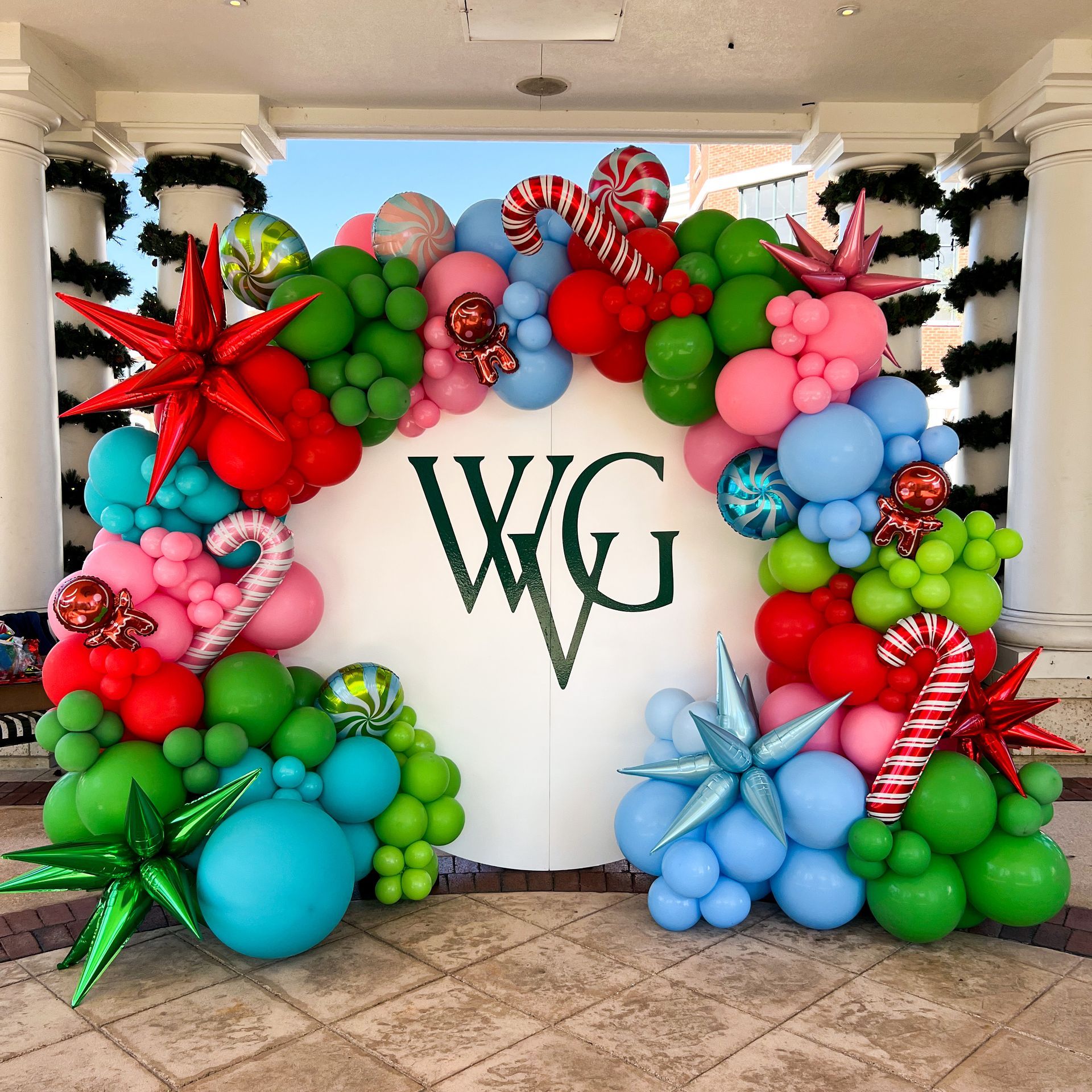 A christmas balloon arch with the initials wg on it