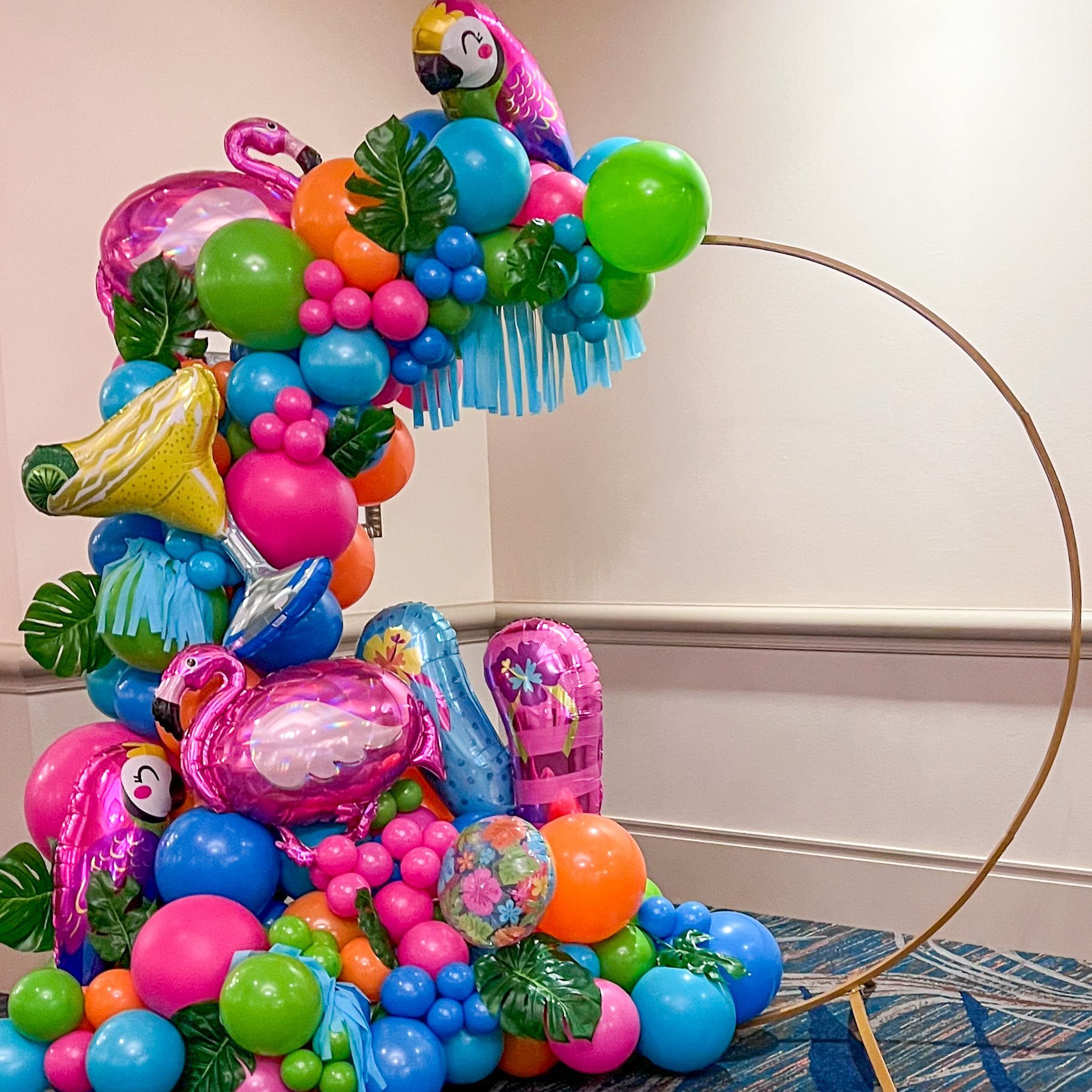 a bunch of colorful balloons are stacked on top of each other