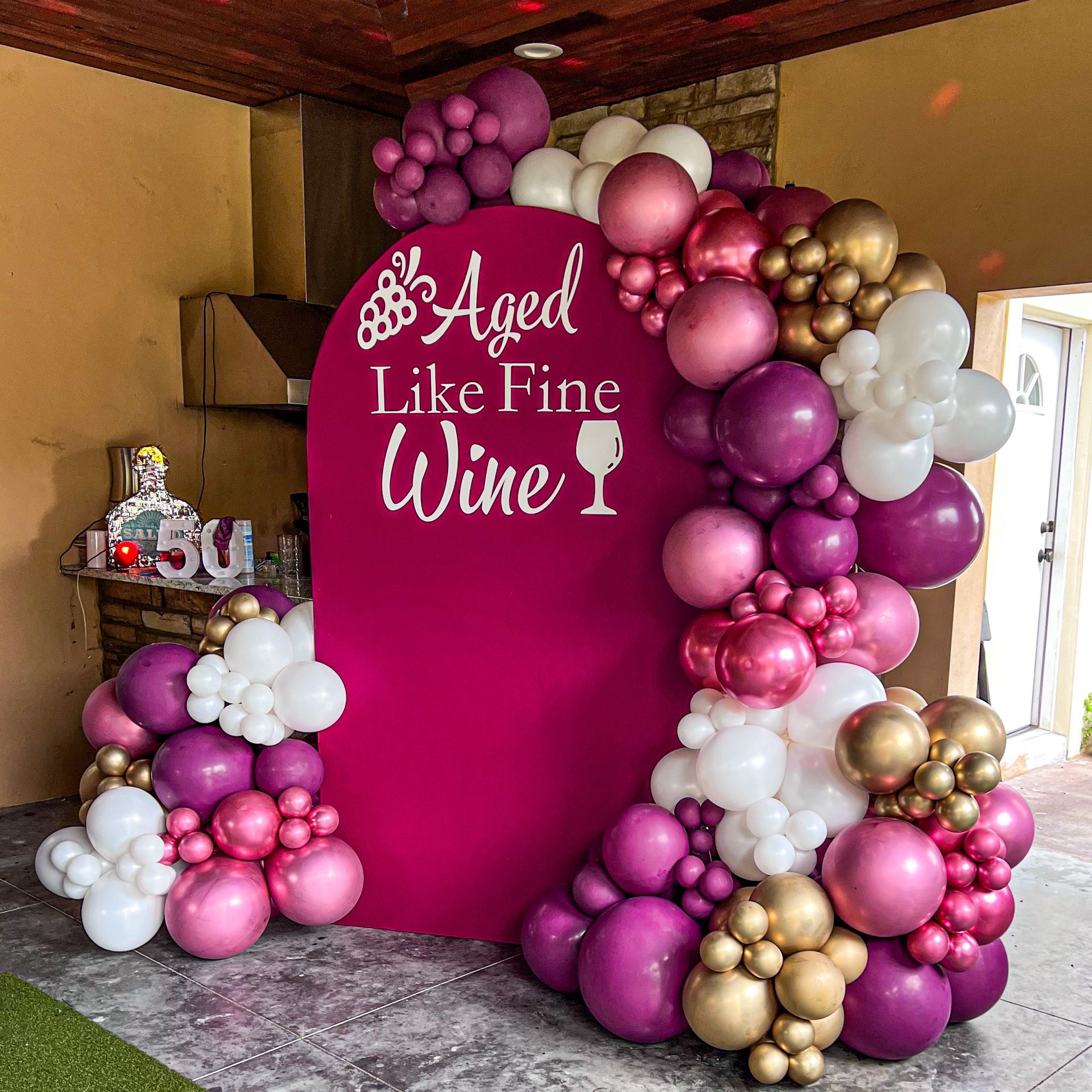 a sign that says aged like fine wine is surrounded by balloons