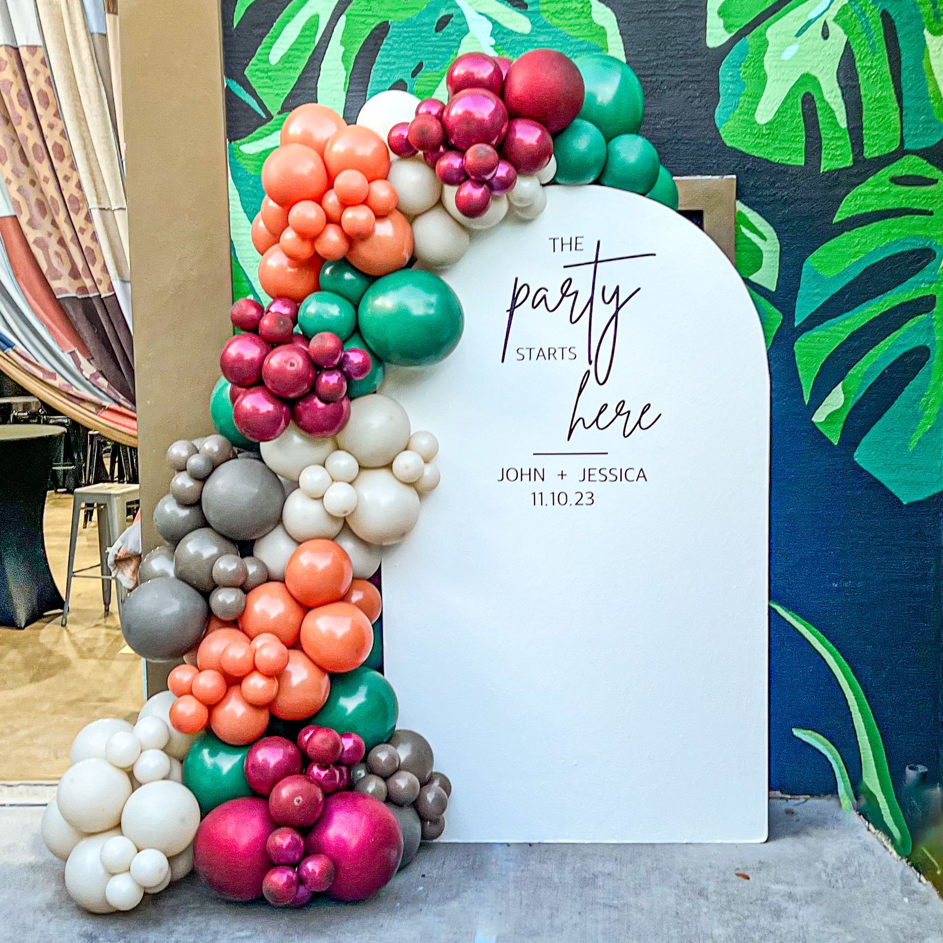 a sign that says the party here is surrounded by balloons .