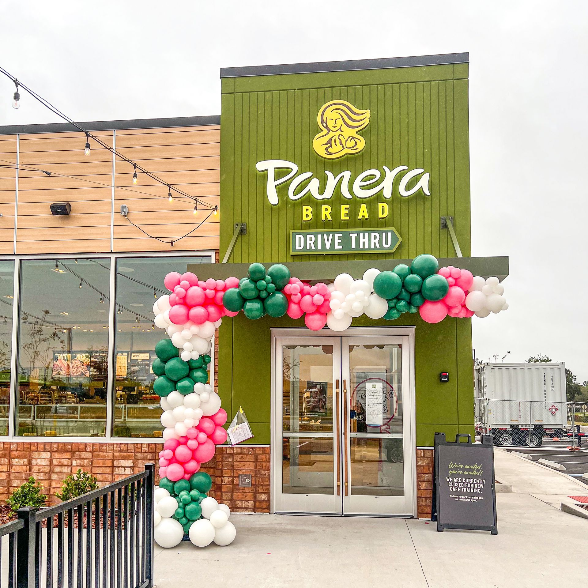A panera bread drive thru is decorated with balloons
