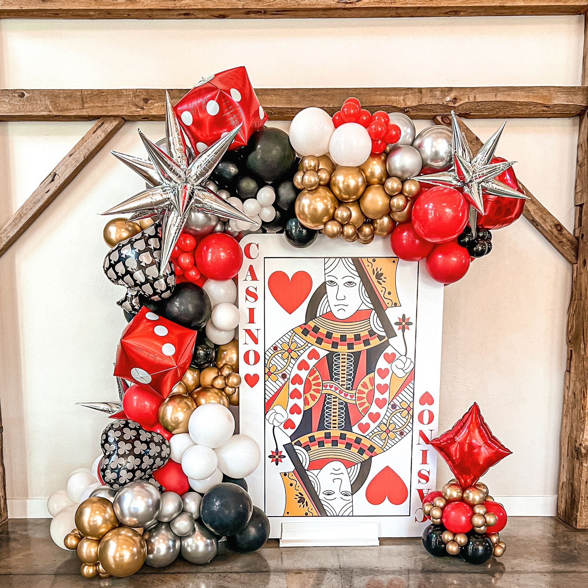 A king of hearts card is surrounded by balloons and dice.