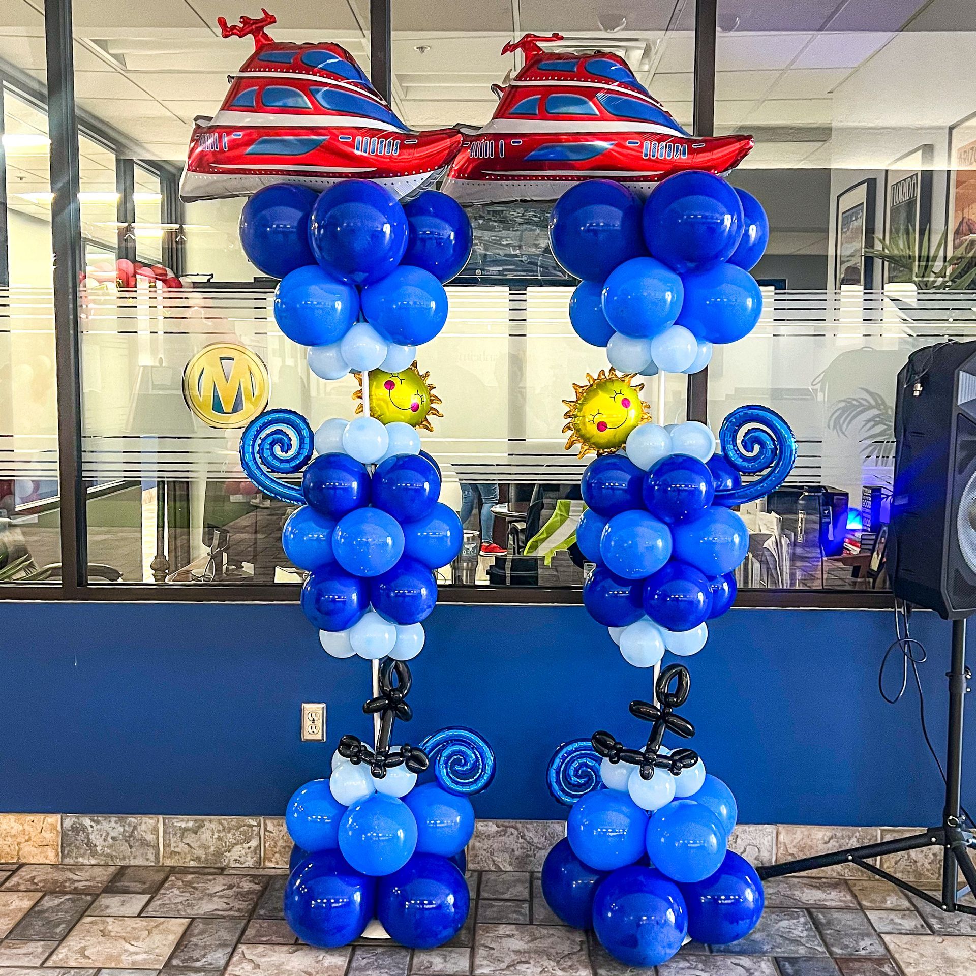 Two columns of blue balloons with boats on top of them