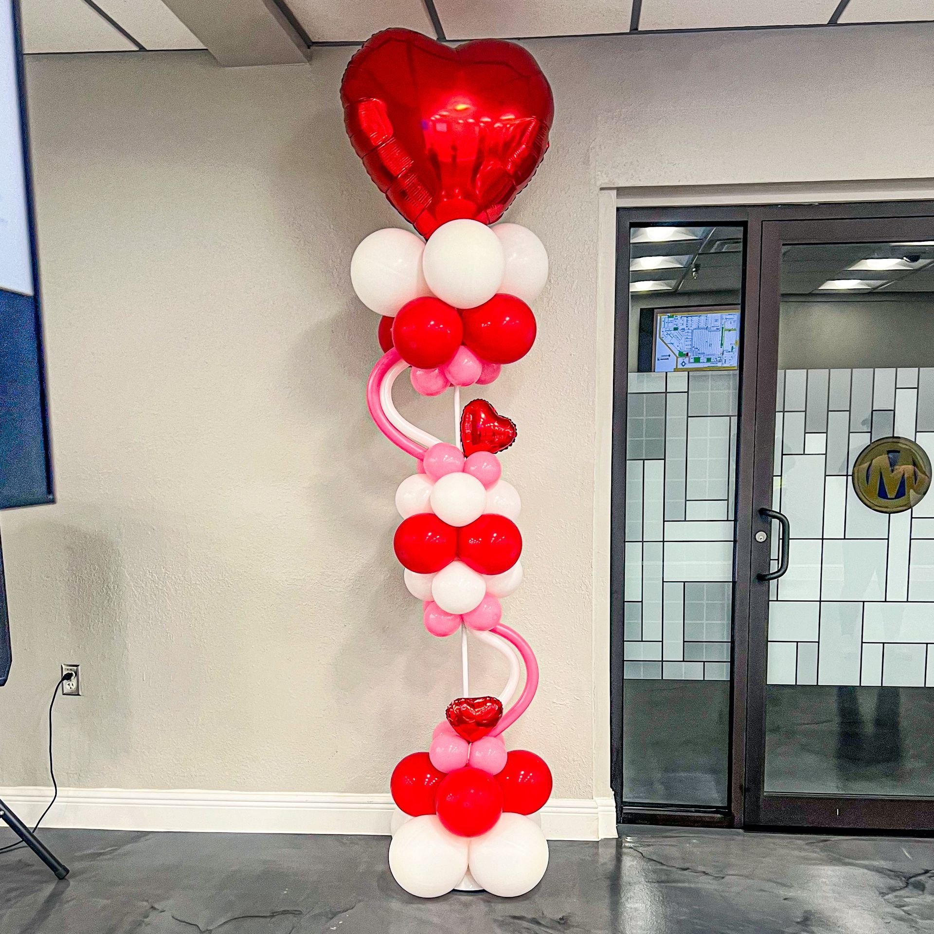 A balloon tower with a heart shaped balloon in the middle