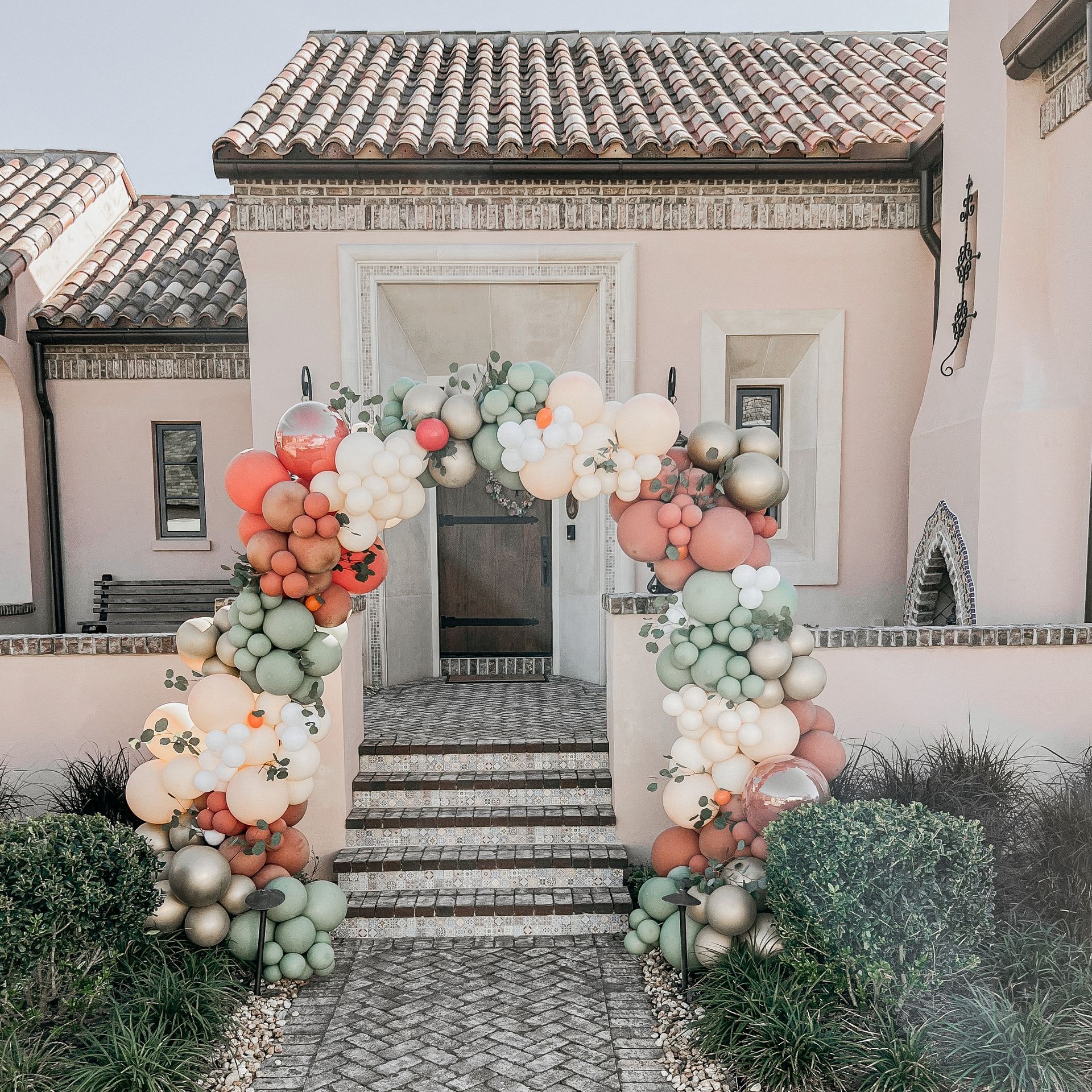 A house with a balloon arch in front of it.