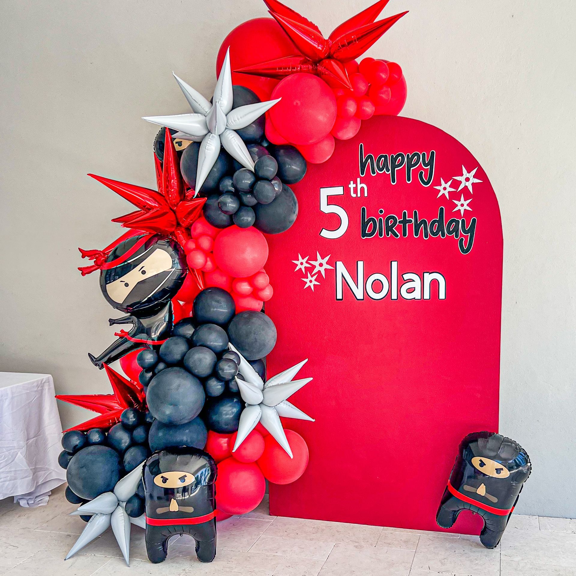 a happy 5th birthday nolan sign with balloons and ninja balloons