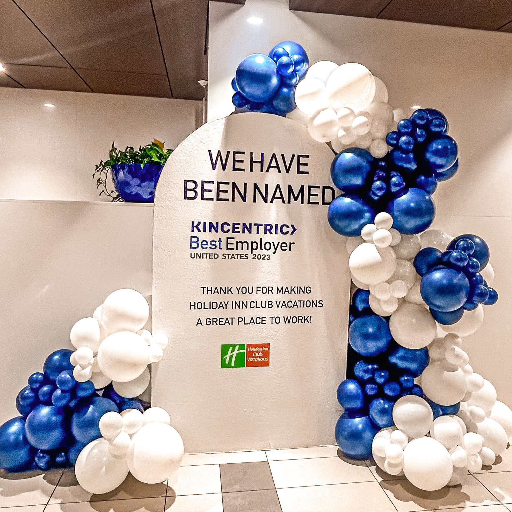 a sign that says we have been named is surrounded by blue and white balloons