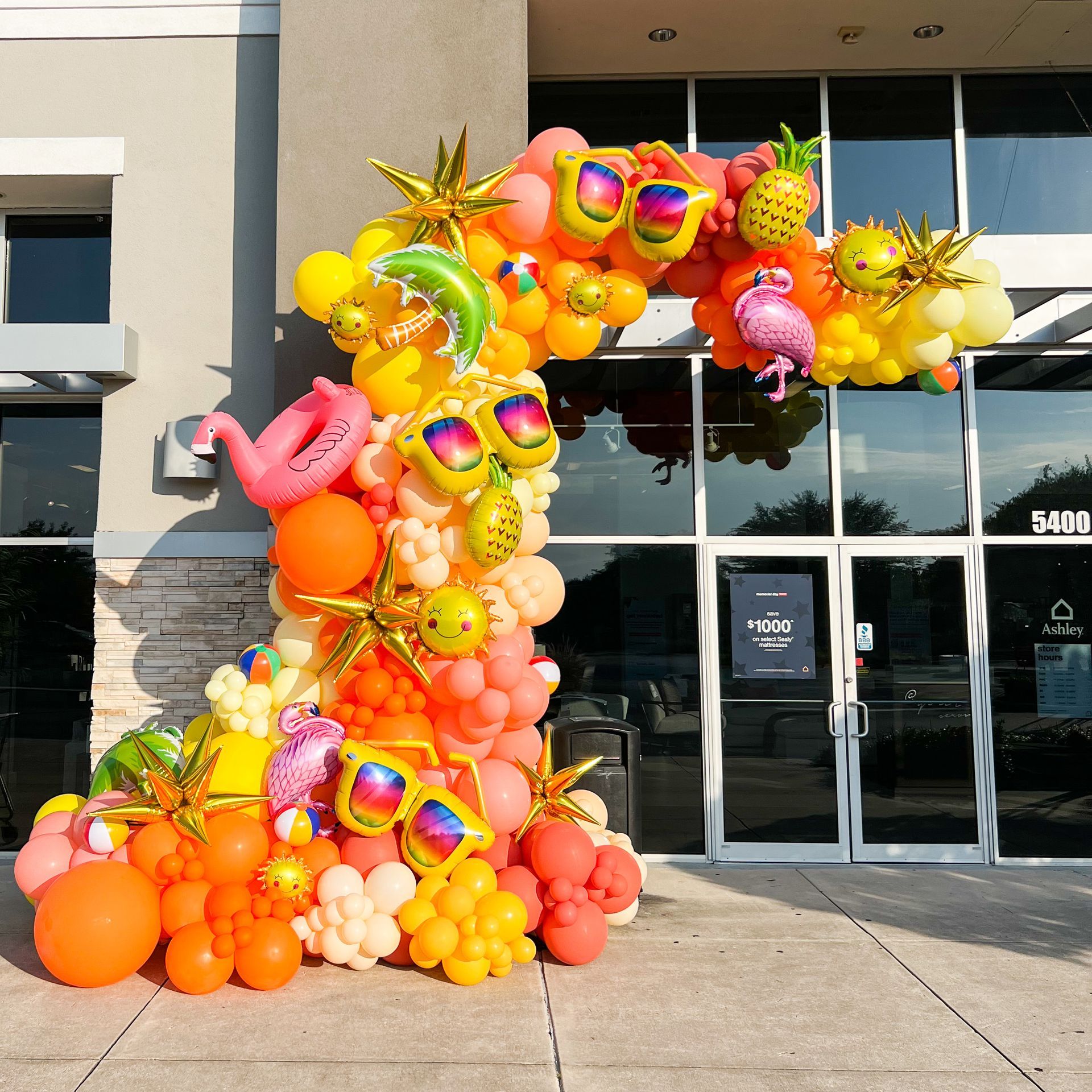 A bunch of colorful balloons in front of a building