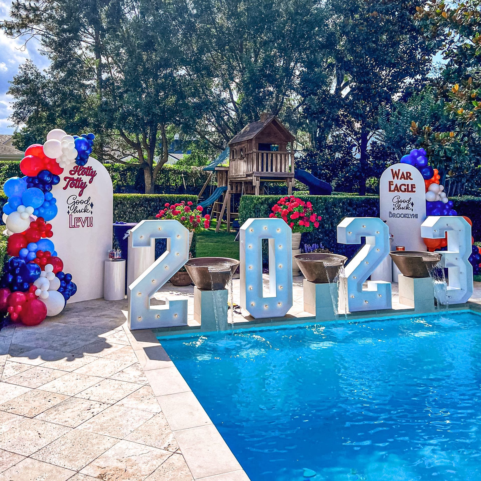 A swimming pool is decorated with balloons and a sign that says 2024