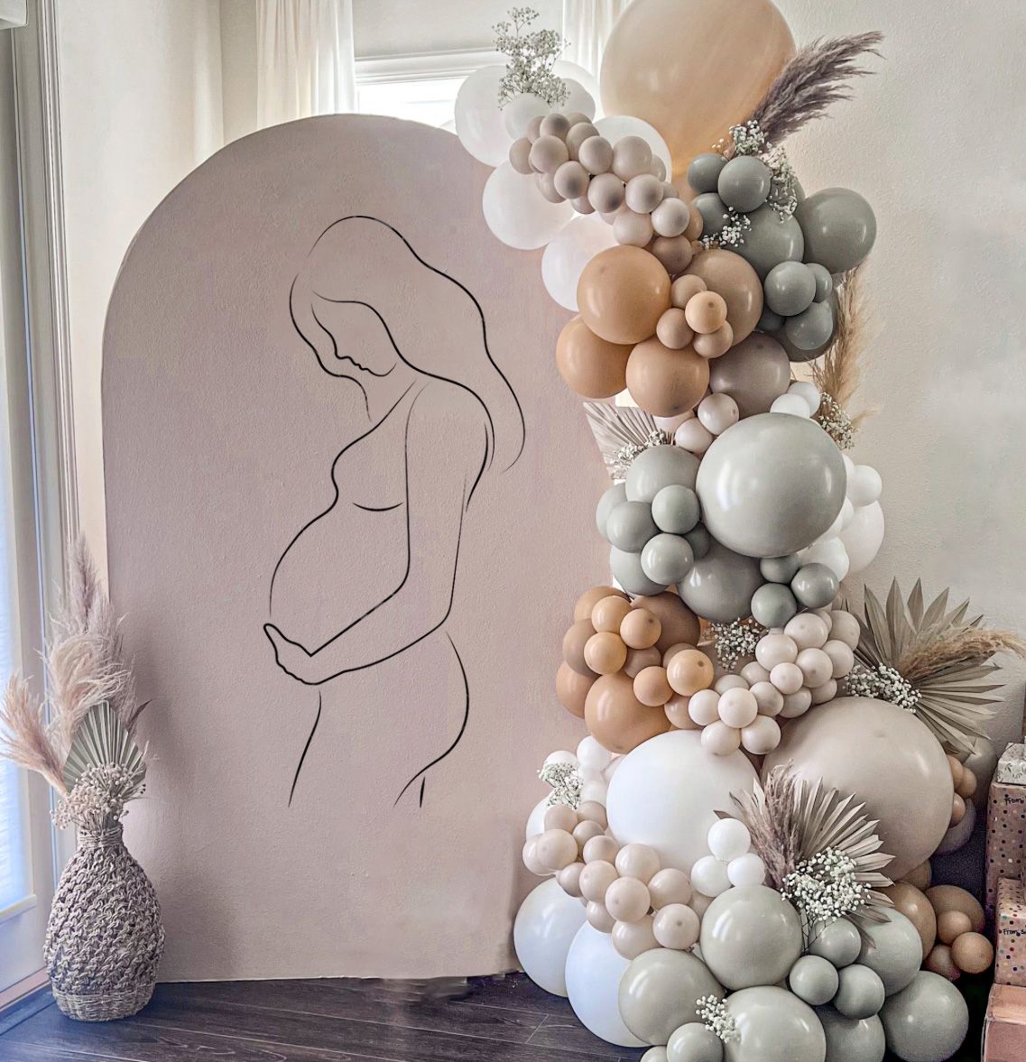 a drawing of a pregnant woman is surrounded by balloons and flowers .