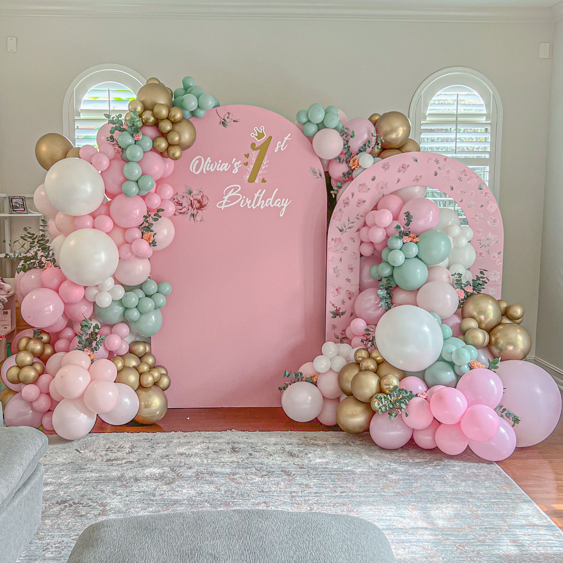 A room decorated with balloons for a girl 's first birthday.