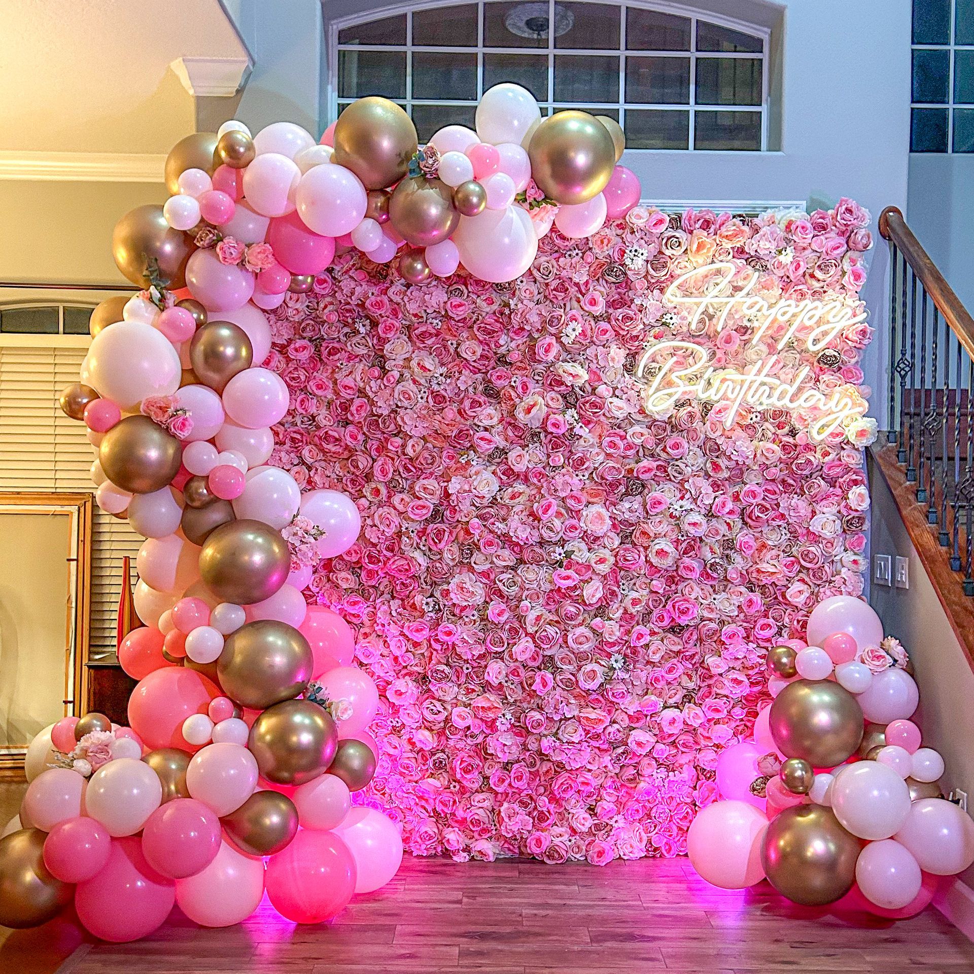 A room filled with pink and gold balloons and flowers.