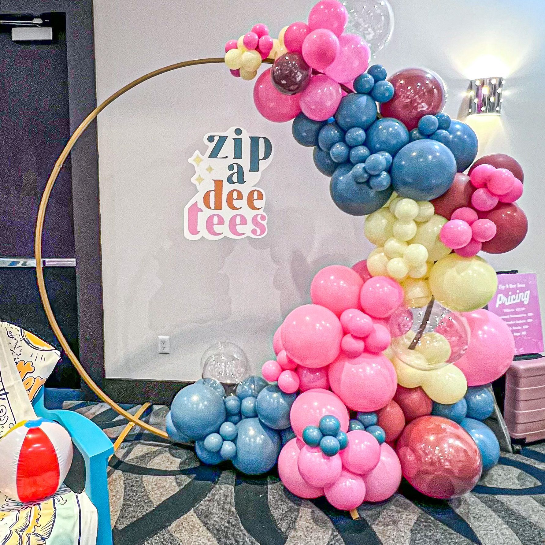 a room filled with balloons and a sign that says zip a dee tees