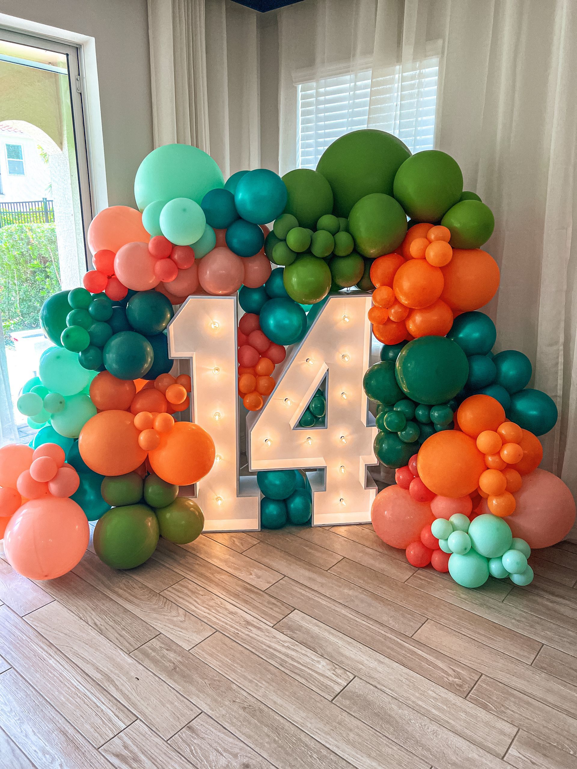 a room filled with balloons and a sign that says 14 .