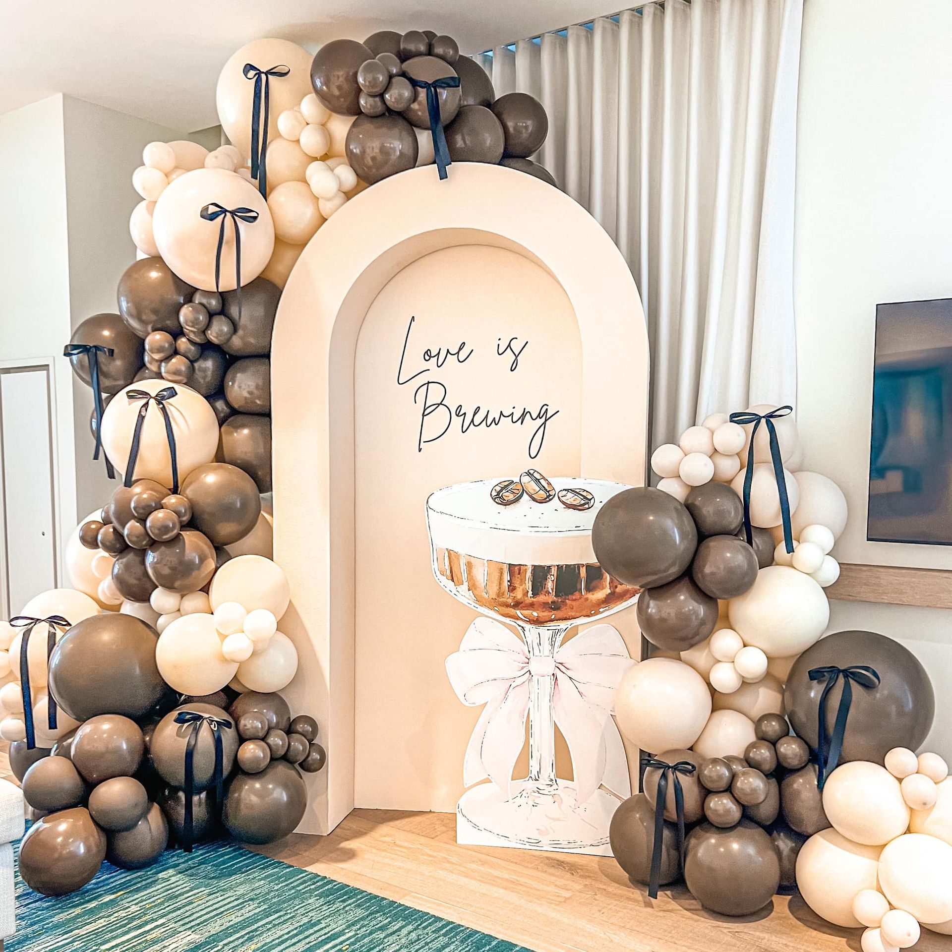 A room filled with balloons and a sign that says `` love is brewing ''.
