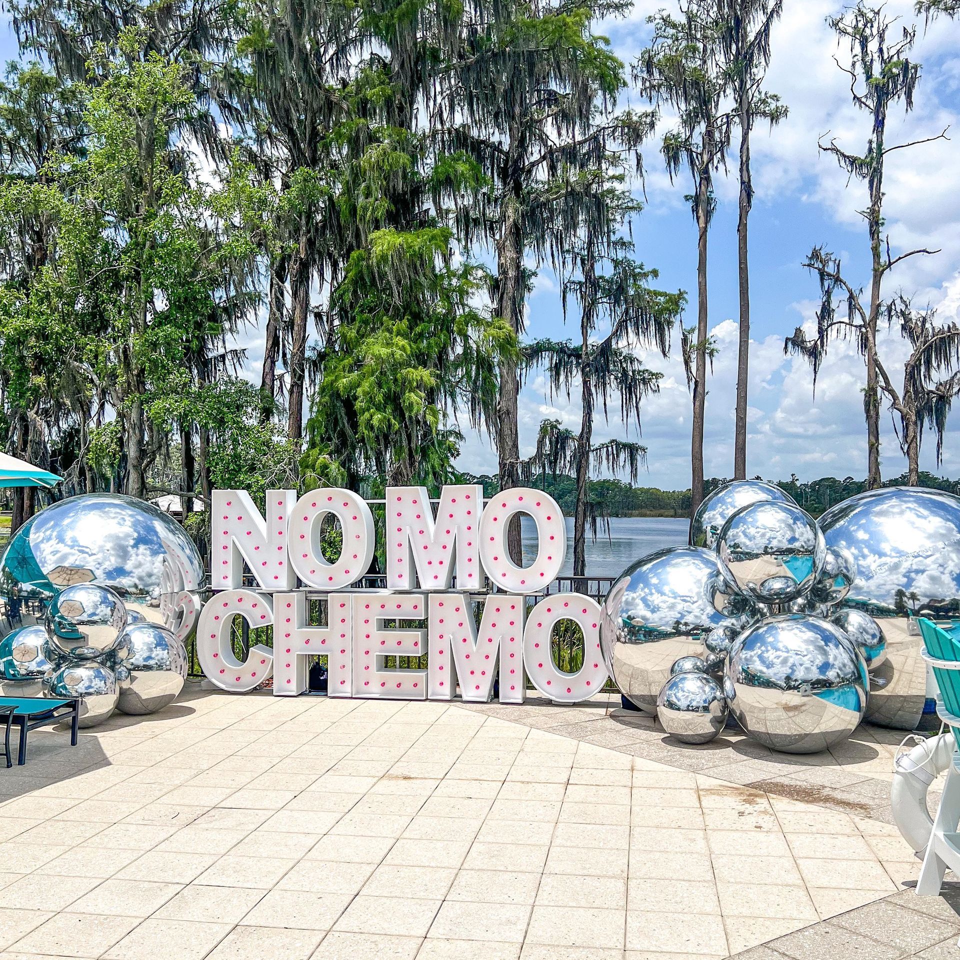 A sign that says no more chemo is surrounded by mirrored balls.