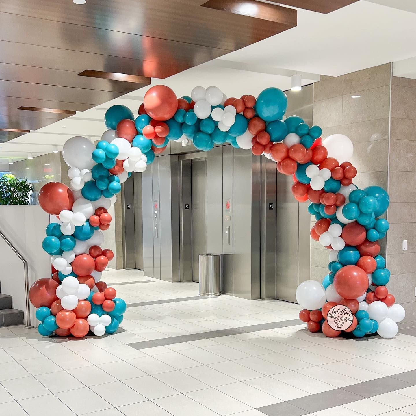 A large arch made of red , white and blue balloons