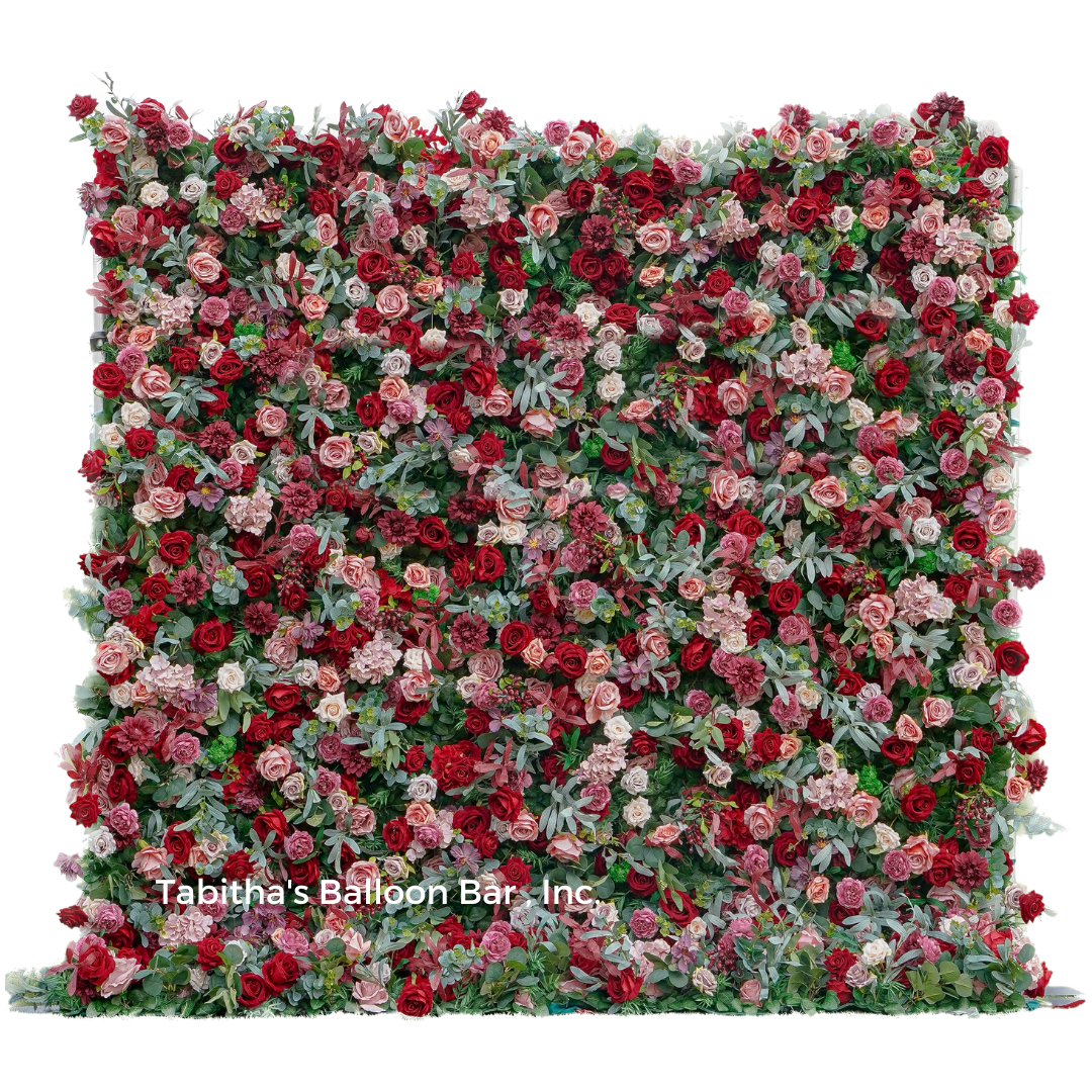 a wall of red and pink roses and greenery on a white background .