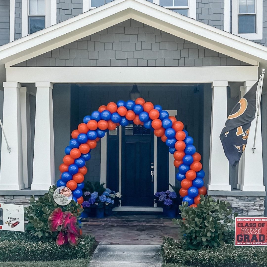 A house with a blue and orange balloon arch in front of it