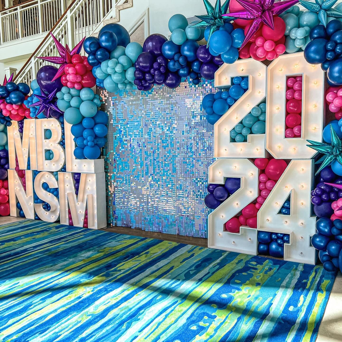 A wall covered in balloons and lights with the numbers 20 and 24.