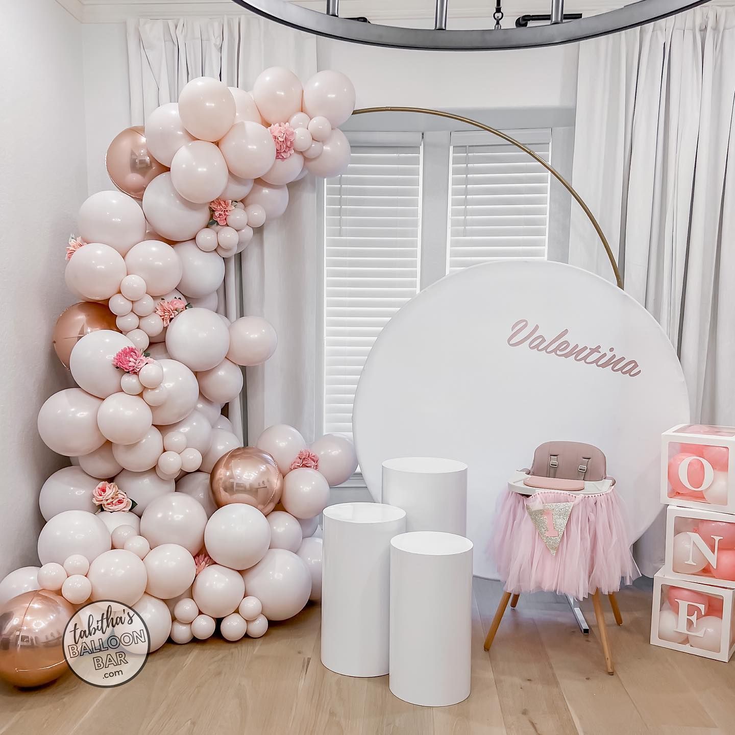 a room filled with lots of pink and gold balloons .