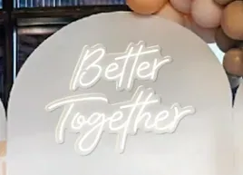 a neon sign that says `` better together '' is surrounded by balloons .