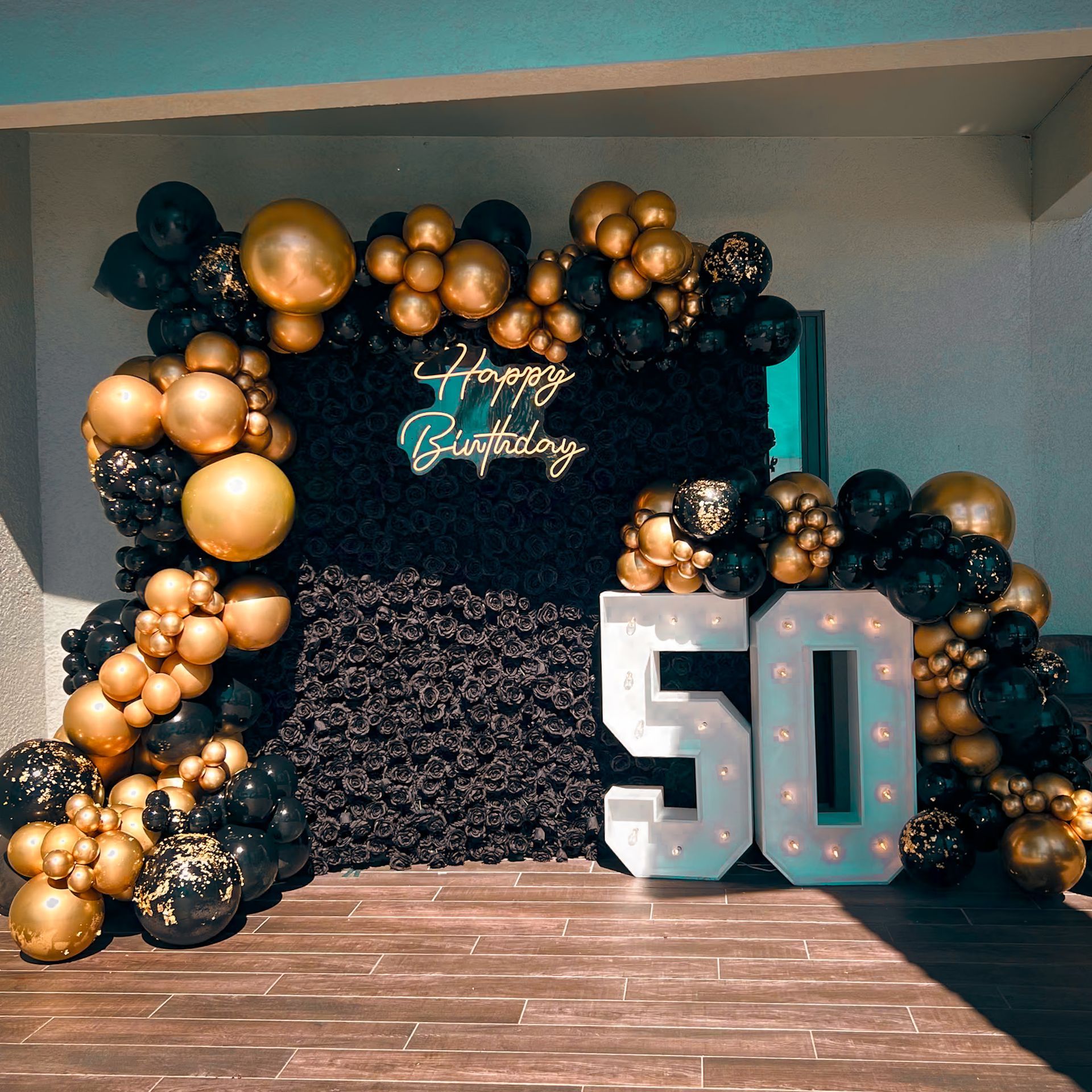 A 50th birthday decoration with black and gold balloons