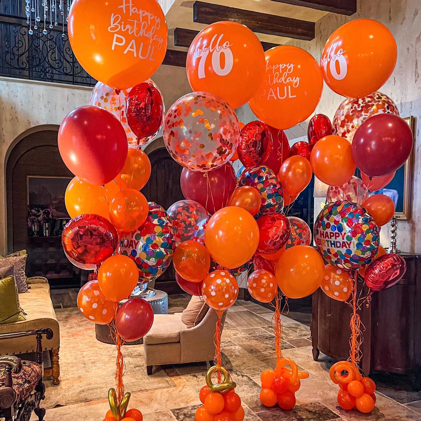 A bunch of orange and red balloons in a living room