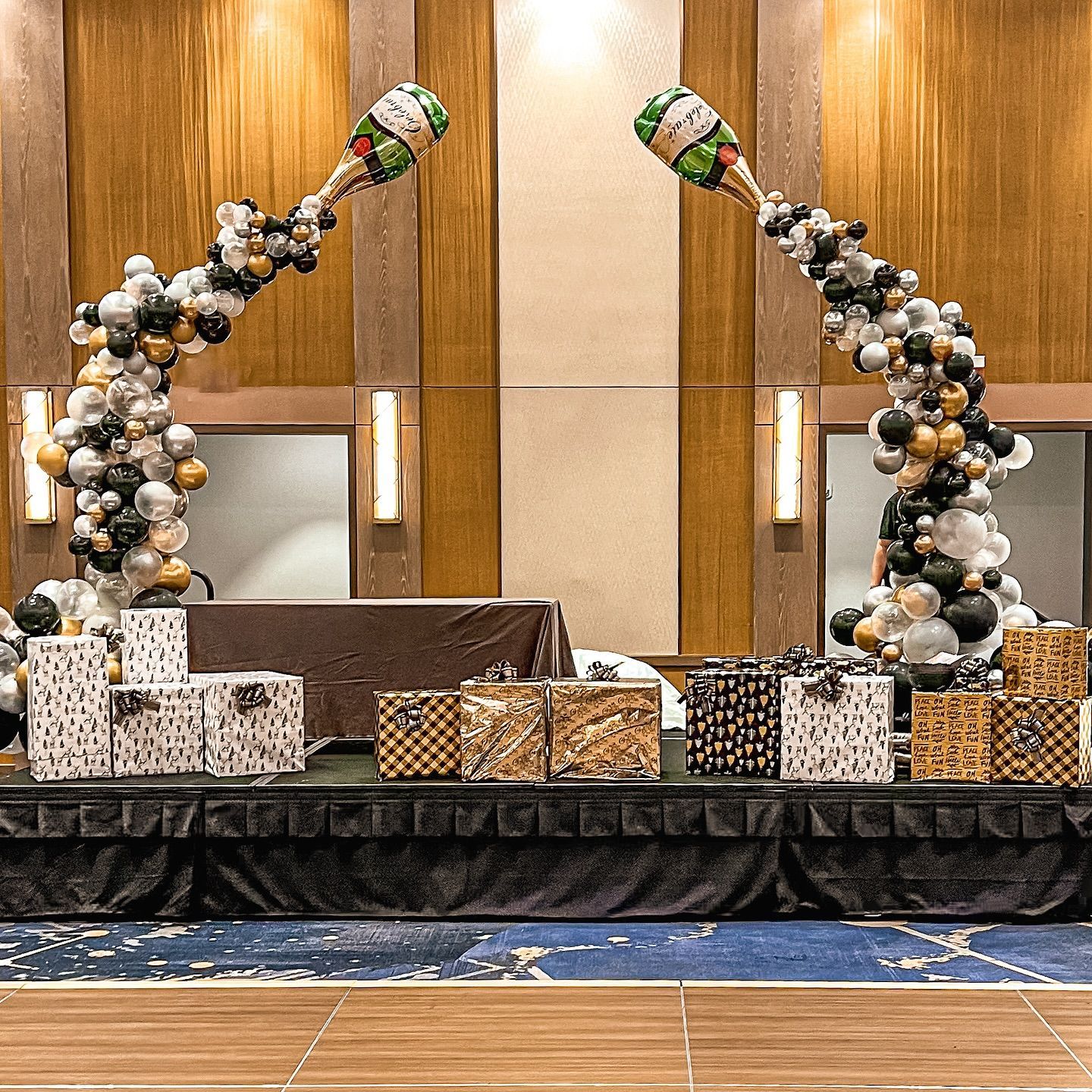 A stage decorated with balloons and gifts for a party.