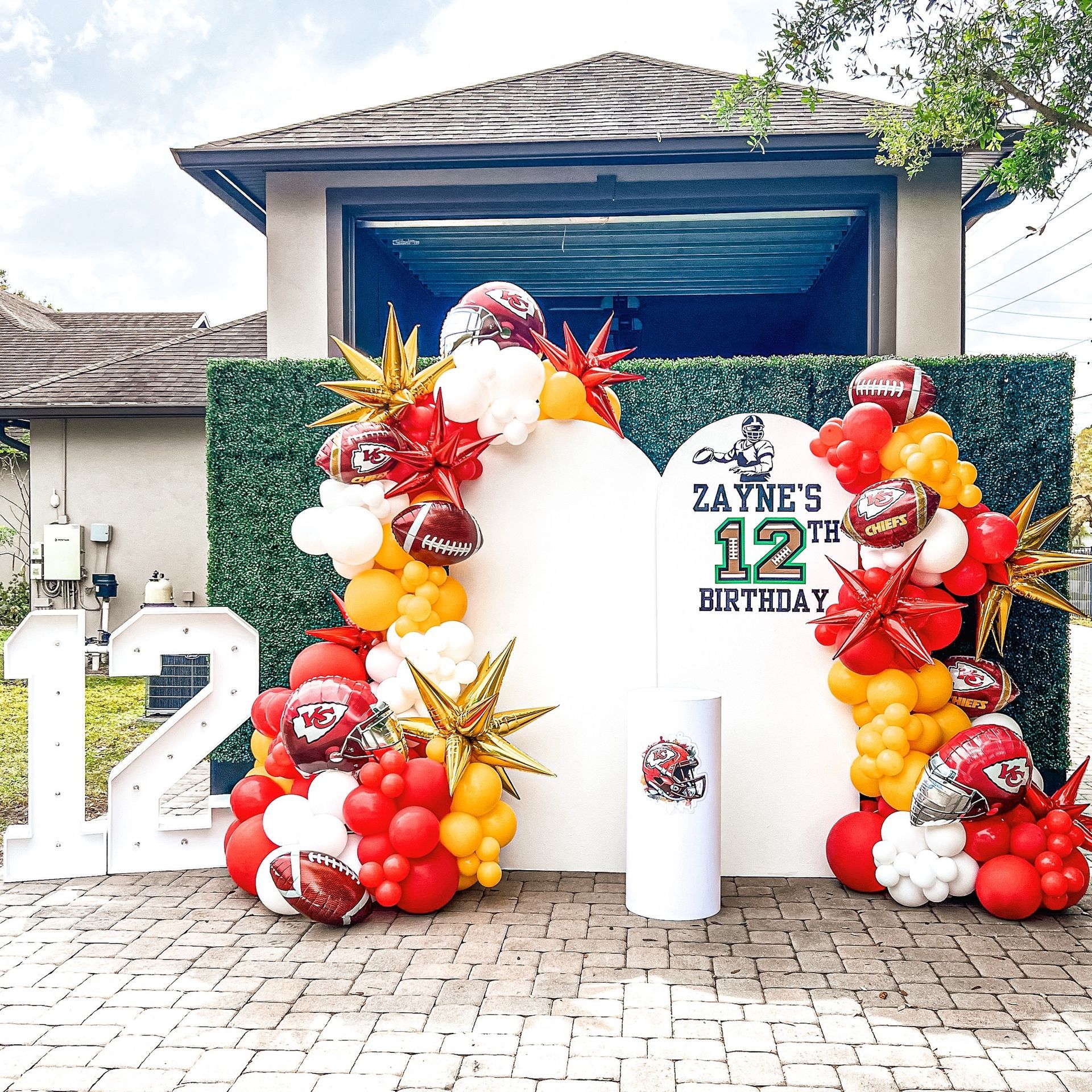 A wall with balloons and a sign that says zayne 's 12th birthday