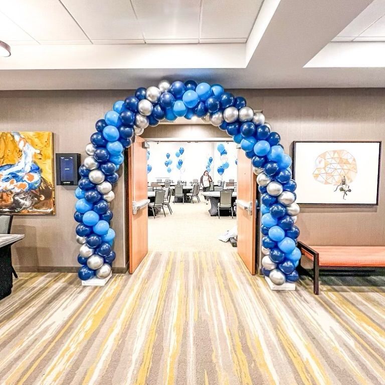 A room with a blue and silver balloon arch