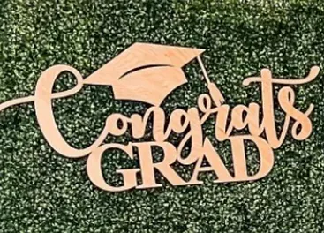 a wooden sign that says `` congrats grad '' with a graduation cap on it .