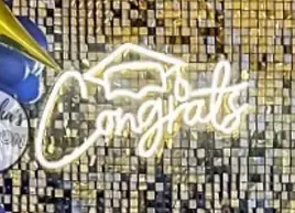 a congratulations sign with a graduation cap and balloons on a wall