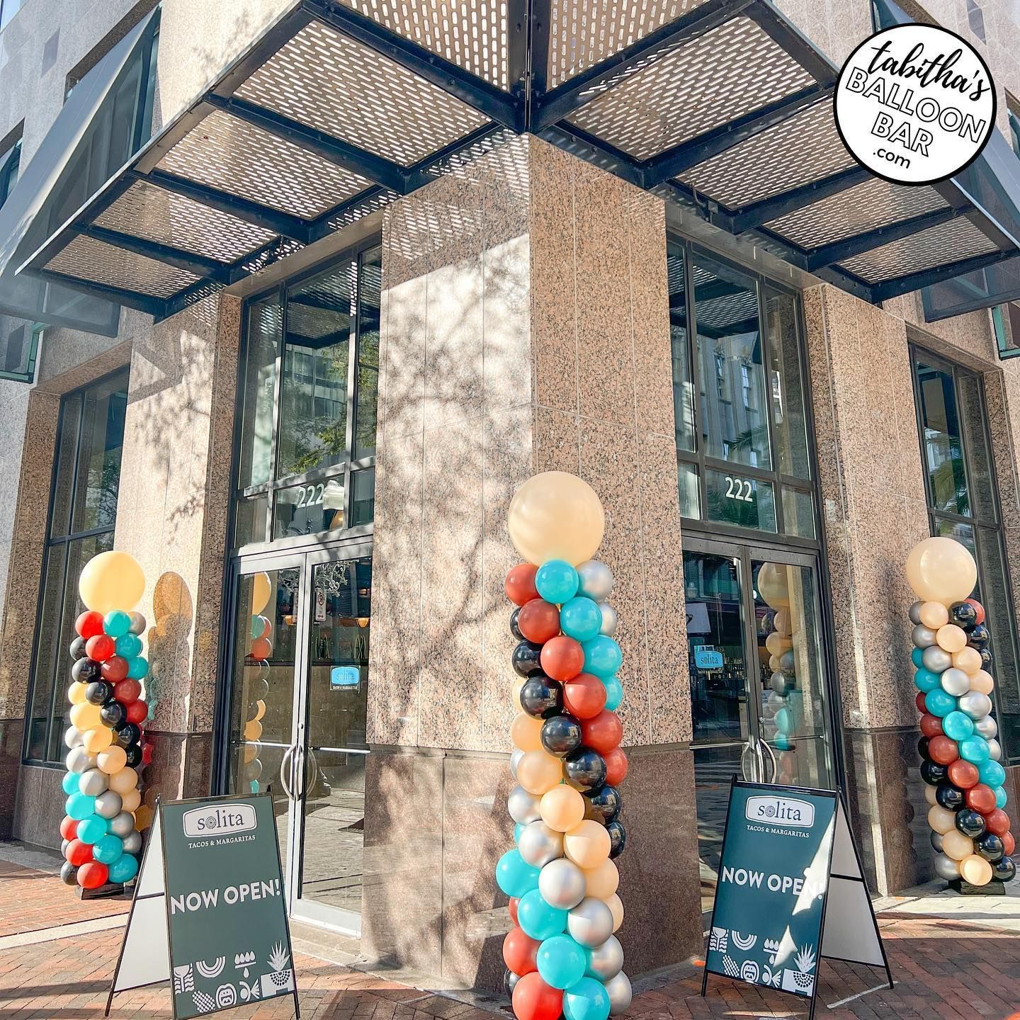 A building with balloons and signs in front of it.