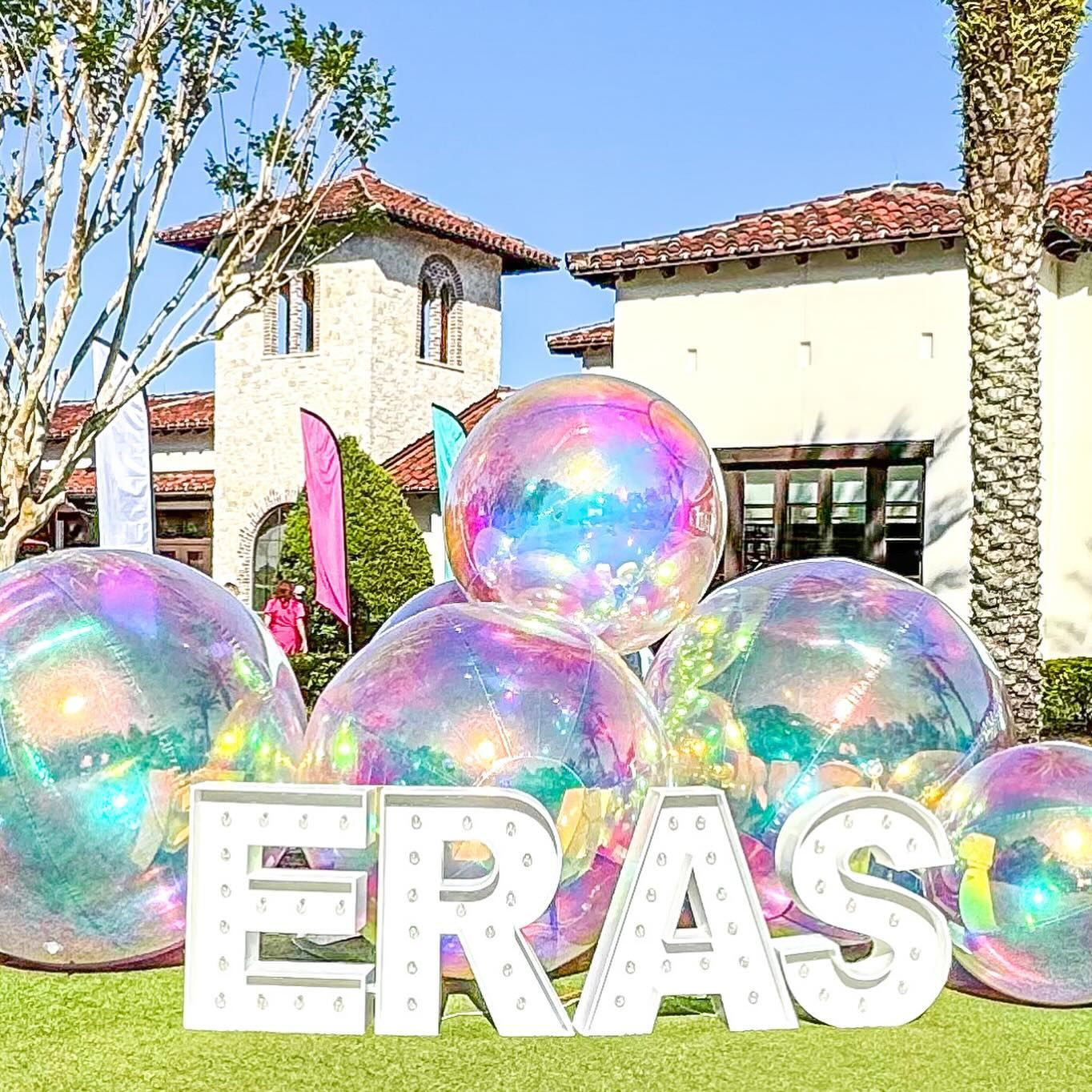 A bunch of balloons are sitting on top of each other in front of a house.